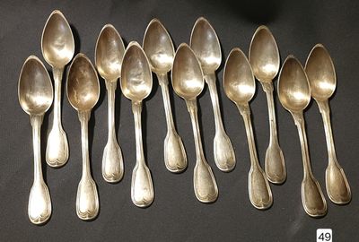 six silver spoons are lined up on a black surface