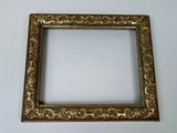 a gold picture frame on a white wall with a white background