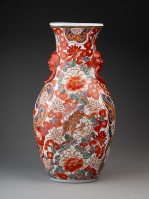 an orange and white vase with a floral design on it