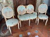 four chairs that are sitting on a tile floor
