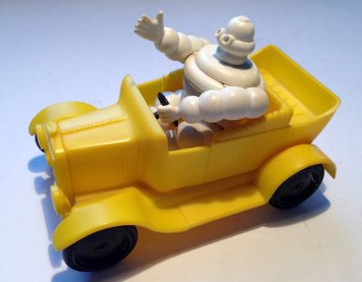 un petit camion jaune avec un homme à l'intérieur