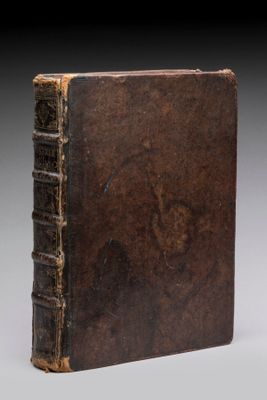 un vieux livre à la couverture brune posé sur une table