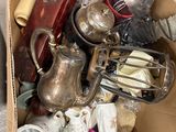 une boîte en carton posée par terre et remplie d'objets divers