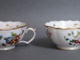 une paire de tasses en porcelaine ornées de motifs floraux sur fond gris