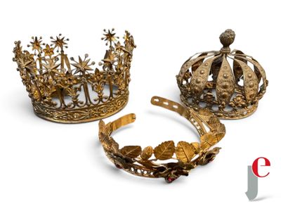 two gold crowns and a tiat are sitting on a white surface