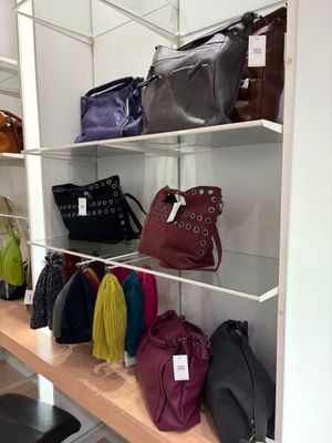 de nombreux sacs à main sur une étagère dans un magasin