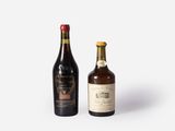 two bottles of wine sitting next to each other on a white surface