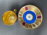 a cup and saucer sitting on a table next to each other