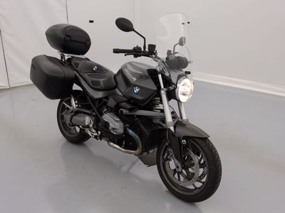 a black motorcycle parked in a room with a white wall