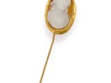 an image of a gold and white broochle on a stick