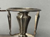 a silver plate with a candle holder on top of it