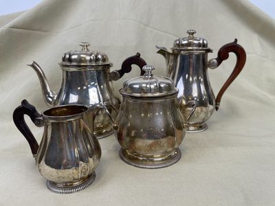 un service à thé et à café en argent composé de quatre pièces, posé sur une nappe blanche
