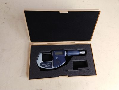 un appareil électronique bleu et noir dans une boîte en bois