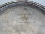 a silver plate with a silver handle on a table