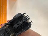 someone is holding a small model of a tank in their hand