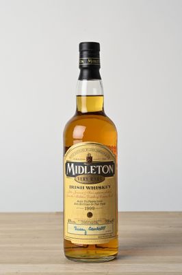 une bouteille de whisky irlandais Midleton posée sur une table en bois