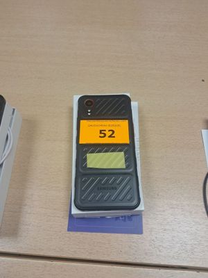 un téléphone portable posé sur une table à côté d'un chargeur