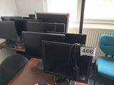 four computer monitors sitting on a desk in a room