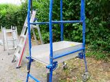 a blue ladder that is sitting on the side of the road