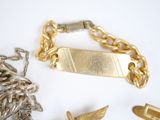 a gold bracelet and a gold chain with a bird on it