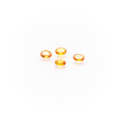a group of three yellow sapphires on a white surface