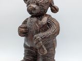 wooden statue of a boy holding a teddy bear in his arms