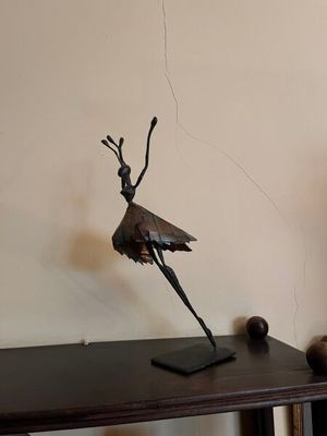 a statue of a bird on a table next to a tv