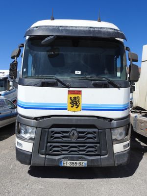 un camion blanc orné d'une bande bleue, garé sur un parking