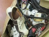 many pairs of shoes in a cardboard box on the floor