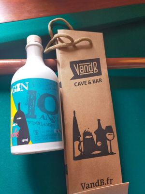 une bouteille de liquide posée à côté d'une bouteille de vin sur une table