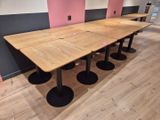 des tables et des tabourets dans une pièce aux murs roses et au parquet