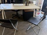 a desk with a chair and a computer on it