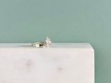 une bague de fiançailles posée sur un bloc de marbre blanc