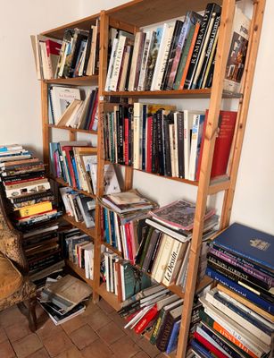 une bibliothèque remplie de livres et une chaise dans un coin