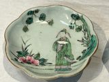 a green bowl with a lady and a bird on it