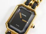 an image of a black and gold watch with a chain around it