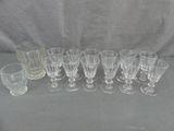 douze gobelets et verres en verre alignés sur une table