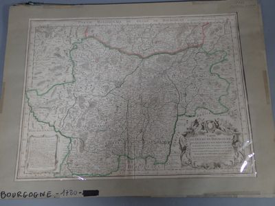 une vieille carte de la France, encadrée, accrochée à un mur bleu