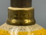 a yellow vase with a black top on a table