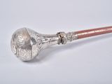 an old silver pipe with a wooden handle on a white surface