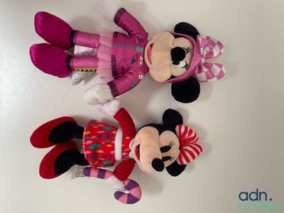 mickey and minnie mouse stuffed animals laying next to each other