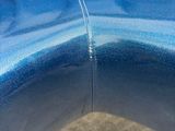 a close up of a blue couch with a curved back