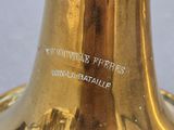 a gold vase with a black handle on a table