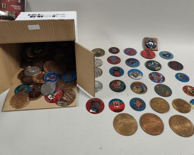 une boîte de pièces posée sur une table à côté d'une boîte d'aimants