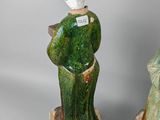 two ceramic figurines of a woman in a green dress and a statue of a man in a black hat