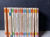 une pile de livres posée sur une table à côté d'un tableau noir