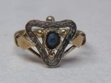 gros plan d'une bague en or avec une pierre bleue au centre