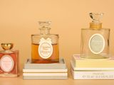three bottles of perfume sitting on top of a stack of books
