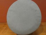 a round object on a wooden table with a red wall in the background