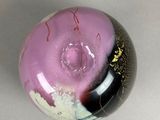 a purple and black glass ball with gold sprinkles on it